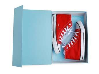 Photo of Pair of stylish red shoes in turquoise box on white background, top view