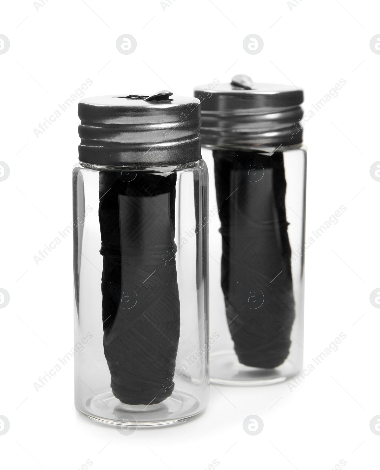 Photo of Rolls of natural organic dental floss in jars on white background