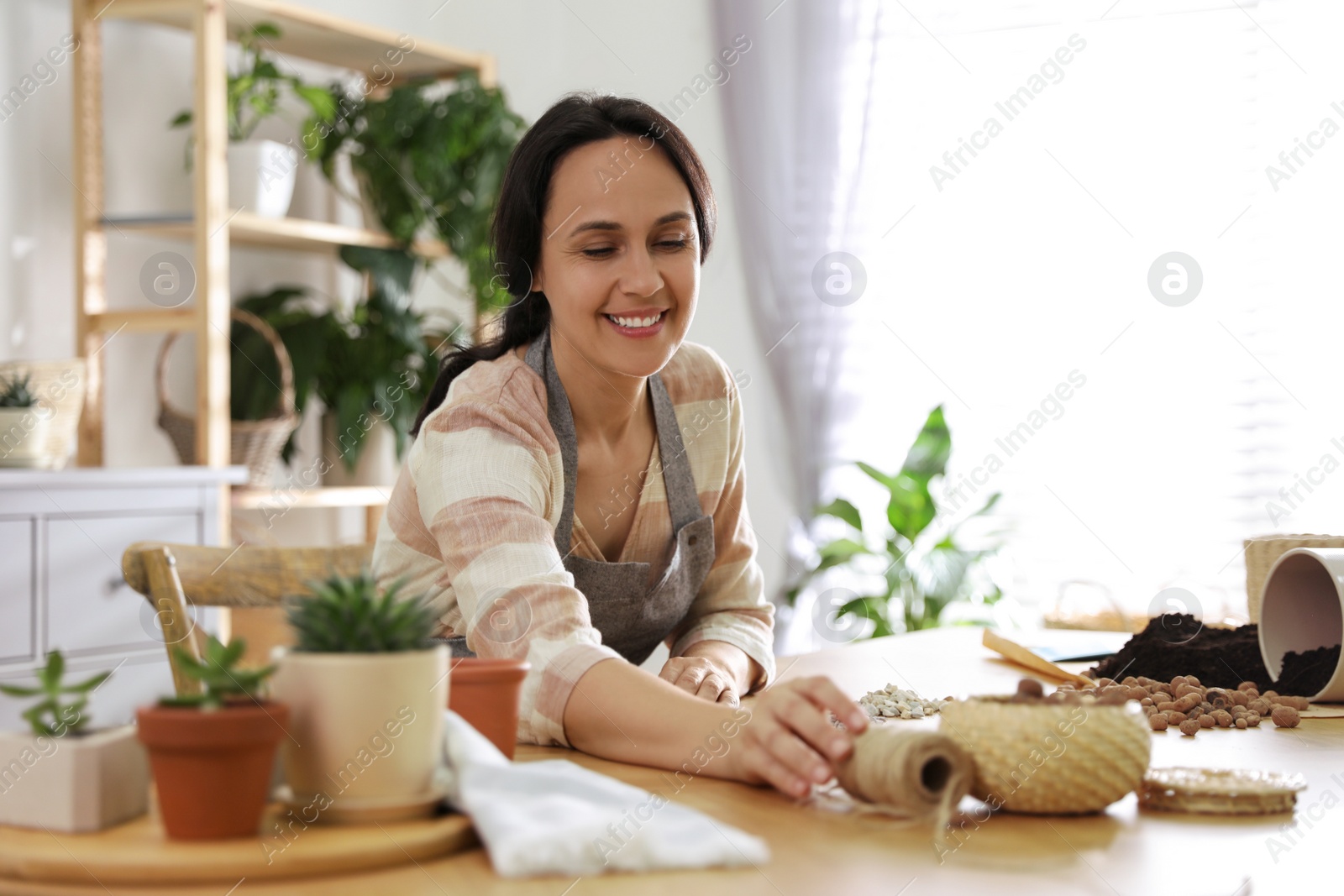 Photo of Mature woman potting plant at home. Engaging hobby