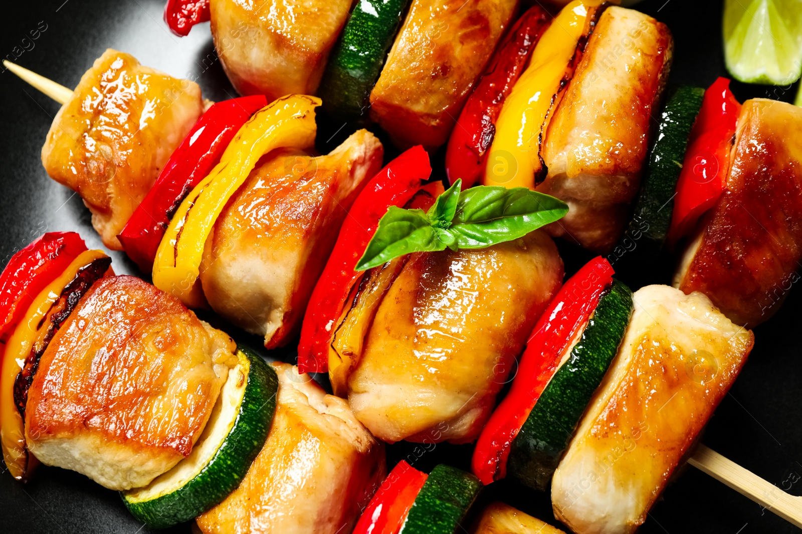 Photo of Delicious chicken shish kebabs with vegetables on plate, closeup