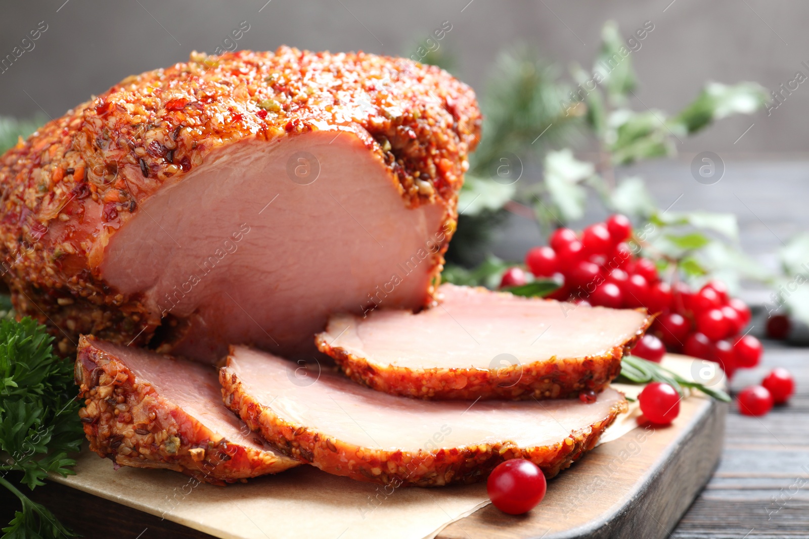 Photo of Board with homemade delicious ham on grey wooden table, closeup. Festive dinner