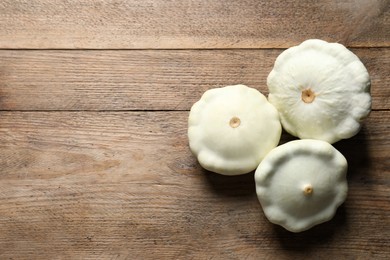 Photo of Fresh ripe white pattypan squashes on wooden table, flat lay. Space for text