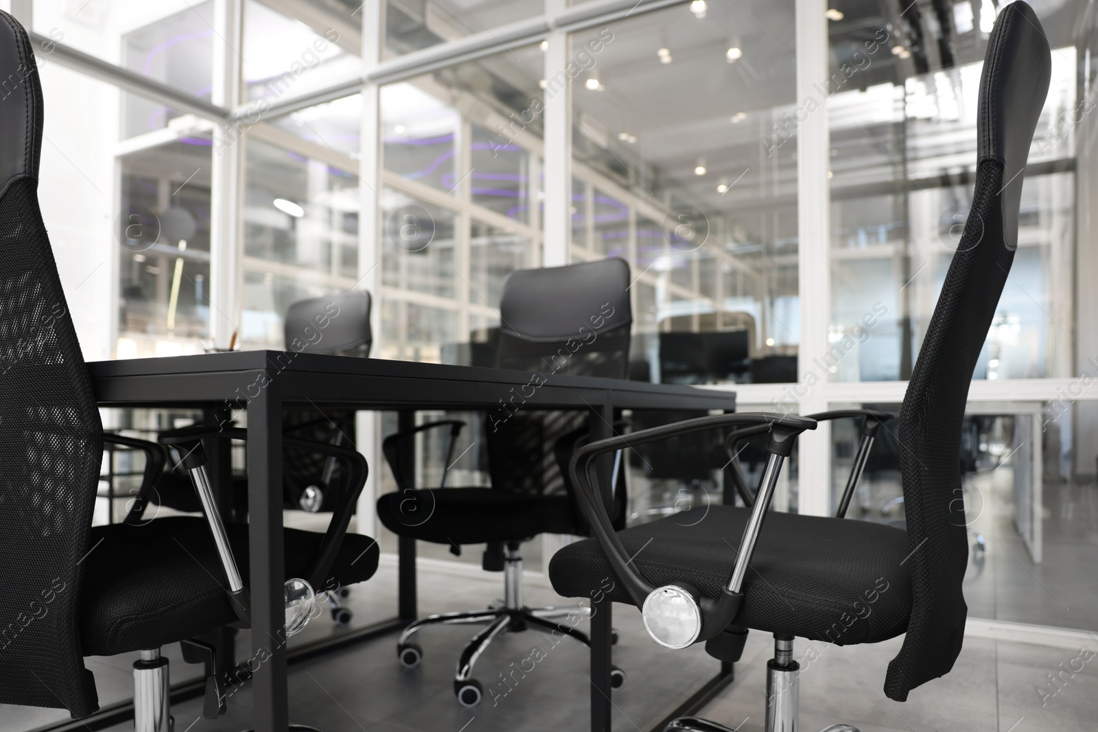 Photo of Comfortable office chairs and tables in meeting room