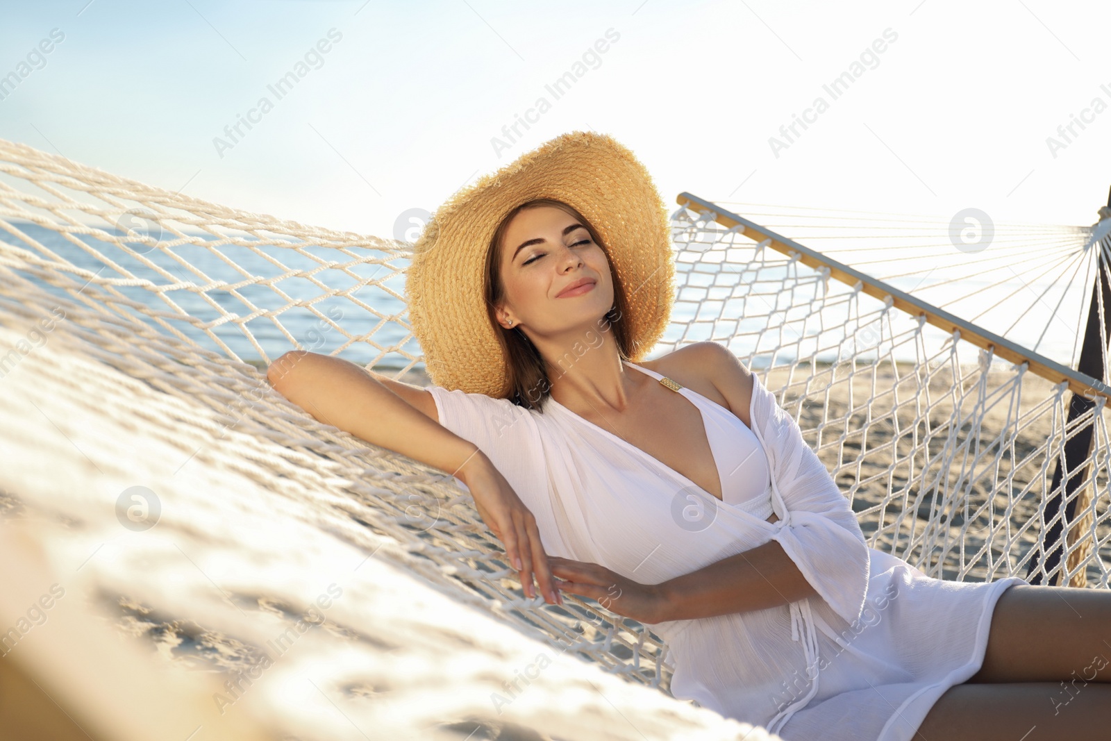 Photo of Young woman relaxing in hammock on beach