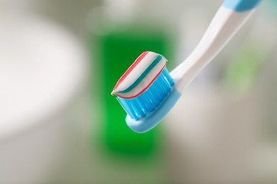 Photo of Toothbrush with paste against blurred background, closeup