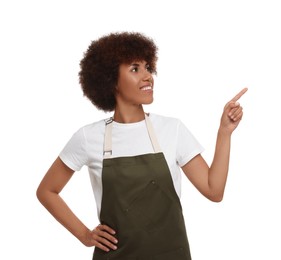 Photo of Happy young woman in apron pointing at something on white background