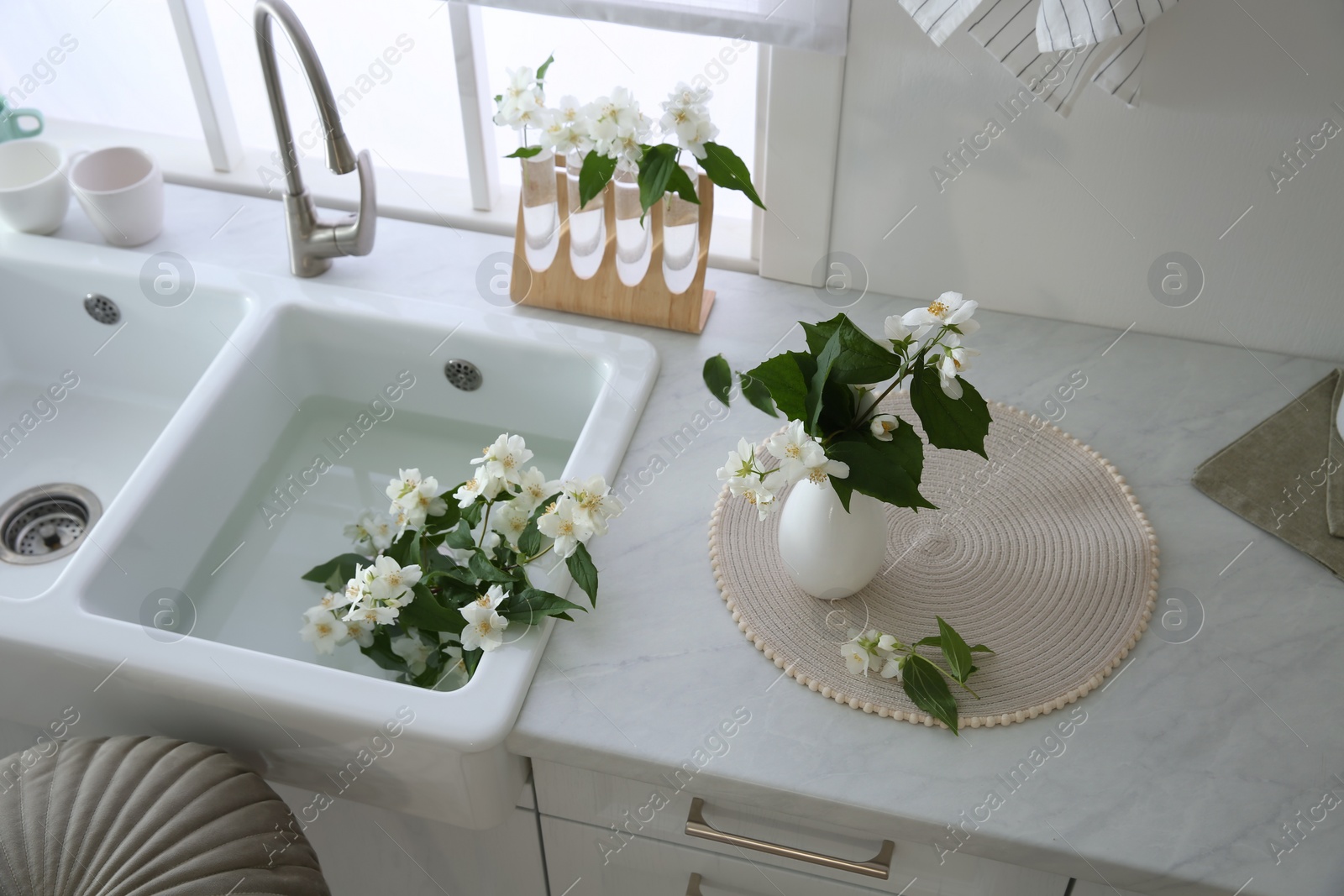 Photo of Bunch of beautiful fresh jasmine flowers in kitchen, above view