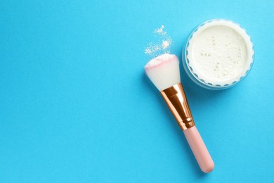 Photo of Rice loose face powder and makeup brush on light blue background, flat lay. Space for text