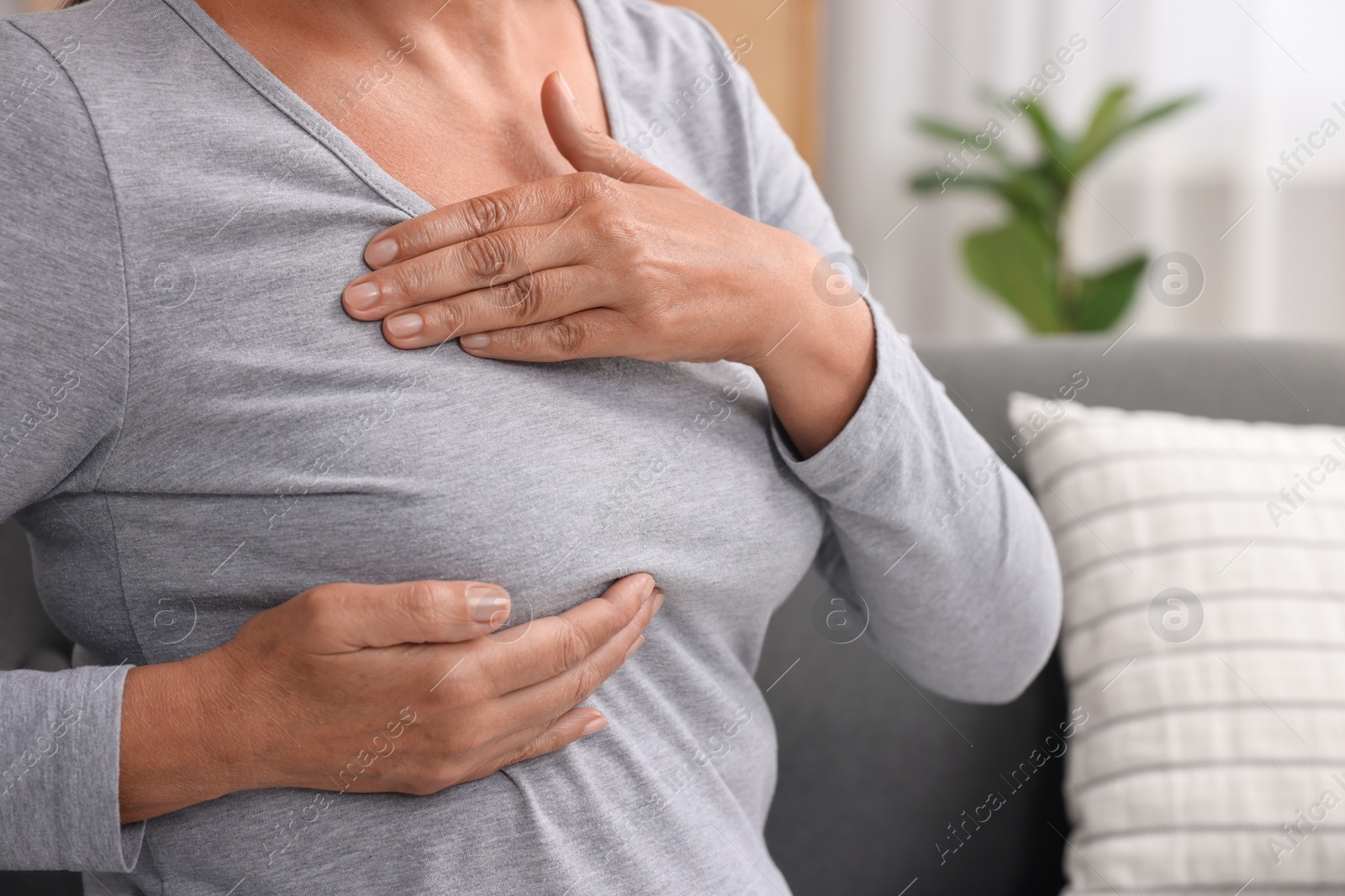 Photo of Woman doing breast self-examination at home, closeup