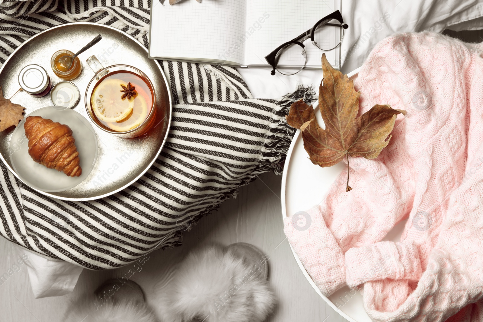 Photo of Flat lay composition with pink sweater on white table at home