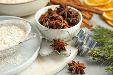 Photo of Cookies cutters and anise on white table, closeup. Christmas biscuits