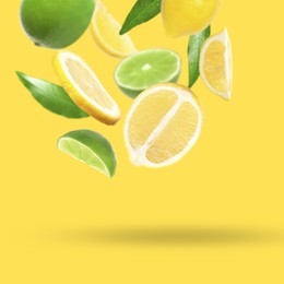 Image of Fresh juicy citrus fruits and green leaves falling on yellow background