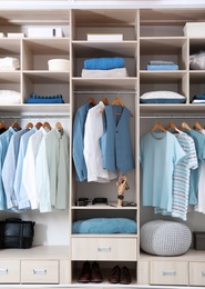 Stylish clothes, shoes and home stuff in large wardrobe closet