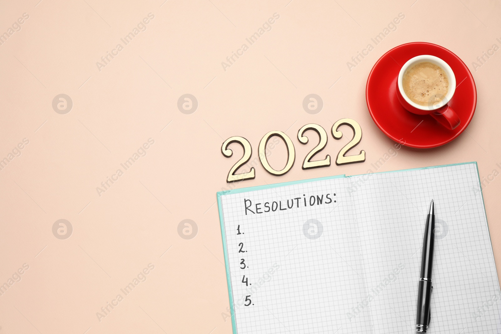 Photo of Making new year's resolutions. Notebook, cup of coffee and 2022 numbers on beige background, flat lay