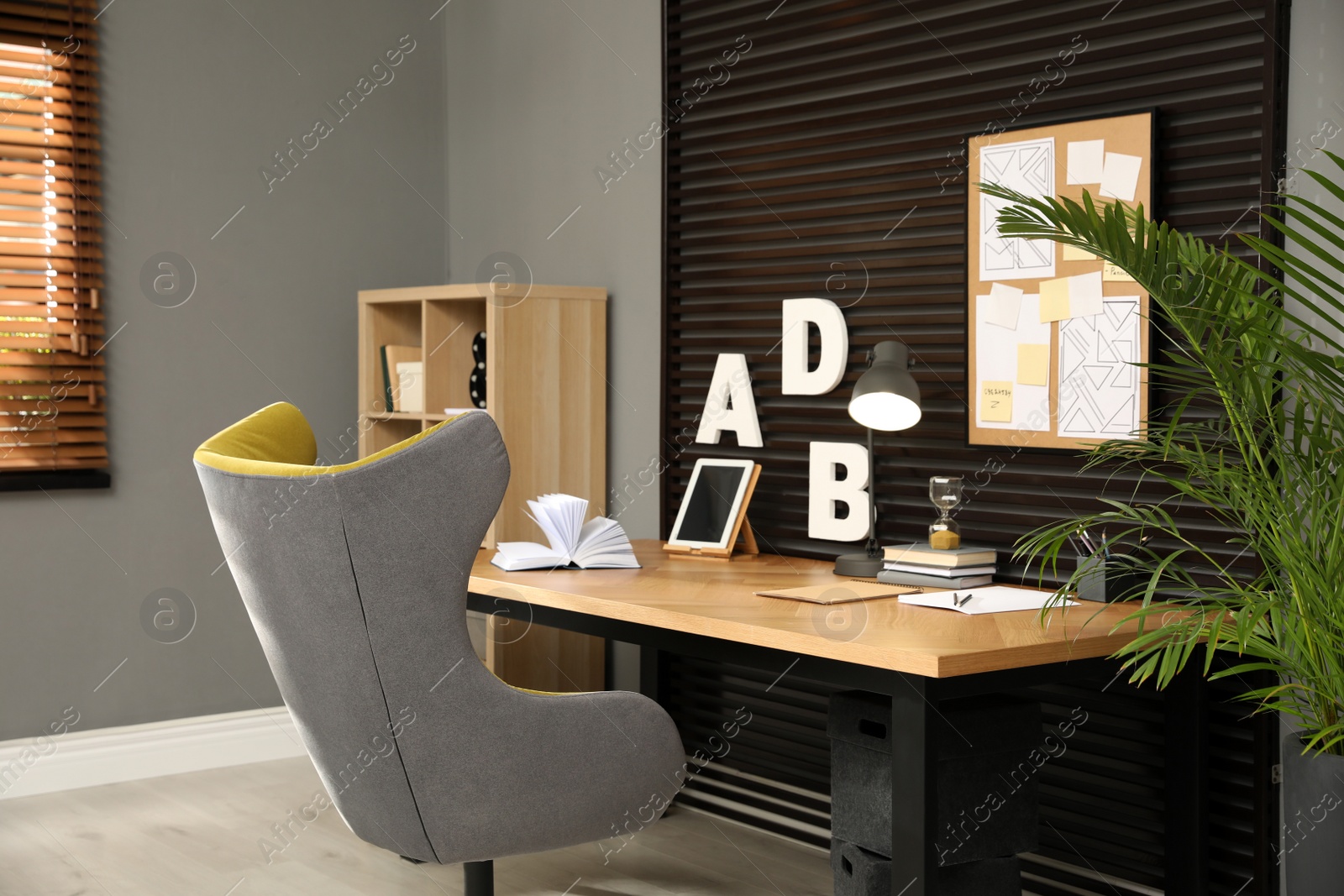 Photo of Comfortable workplace with wooden table and armchair