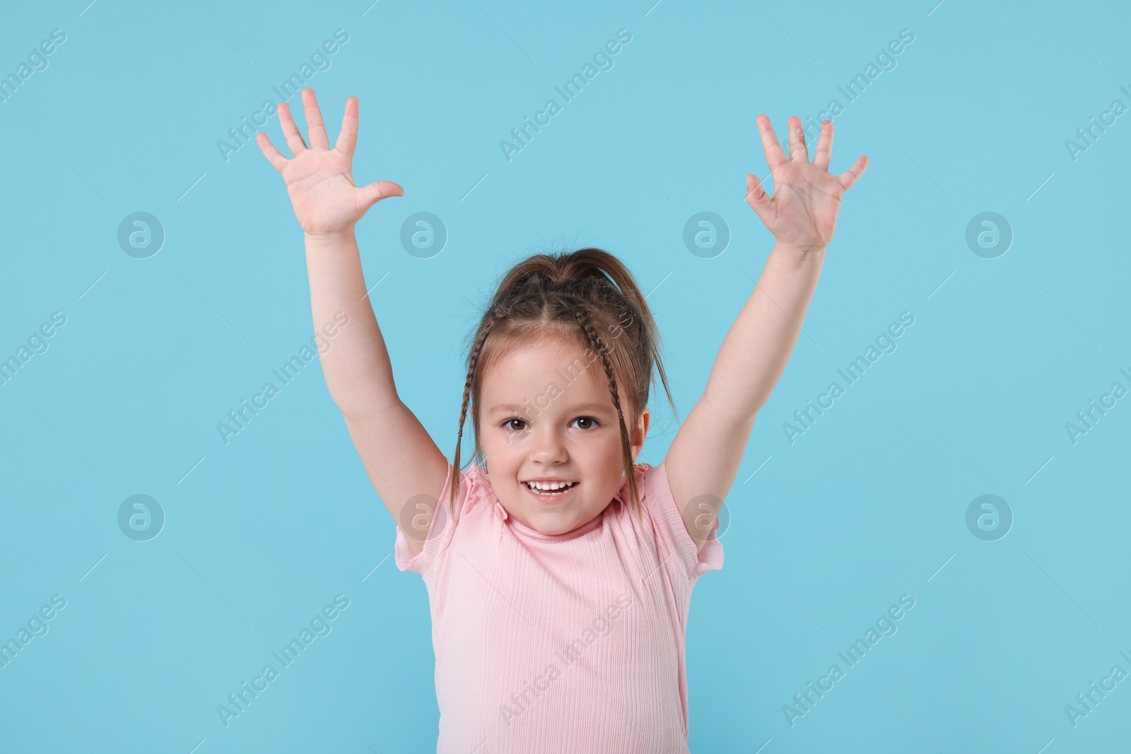 Photo of Cute little girl posing on light blue background