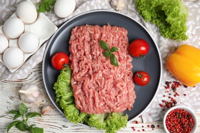 Photo of Raw chicken minced meat and ingredients on white wooden table, flat lay