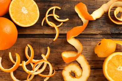 Photo of Orange fruits with peels on wooden table, flat lay