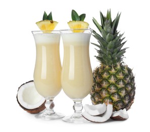 Tasty Pina Colada cocktail and ingredients on white background