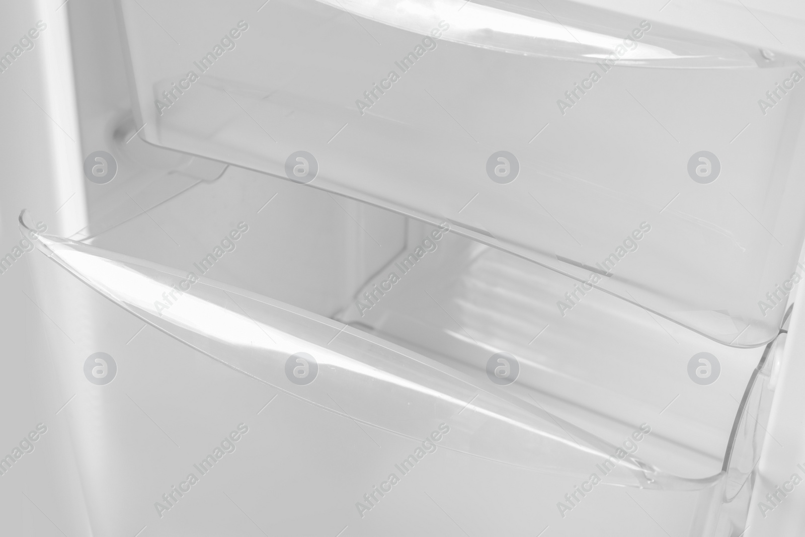 Photo of Modern open refrigerator with empty shelves, closeup