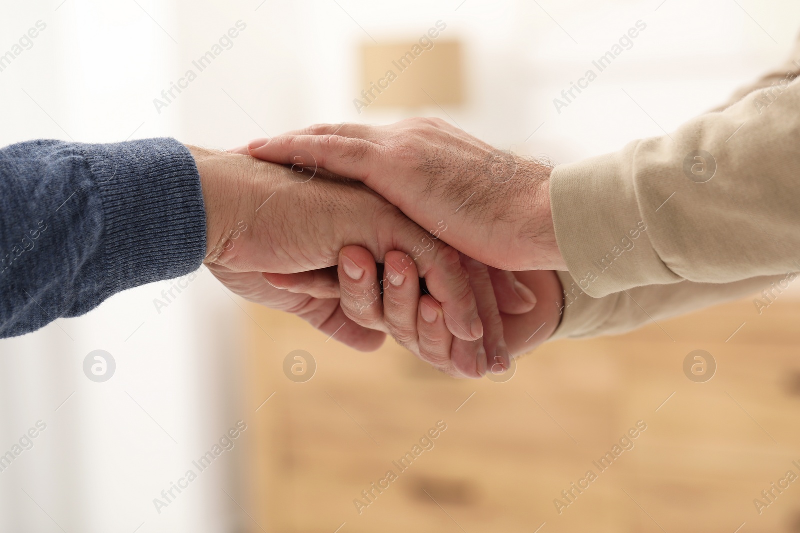 Photo of Trust and deal. Men joining hands indoors, closeup