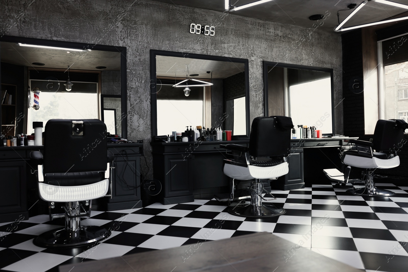 Photo of Stylish monochrome interior of modern barbershop. Equipped workplace