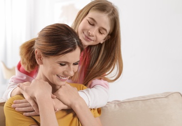 Teenager daughter hugging her mother at home