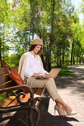 Photo of Beautiful woman working with laptop in park