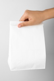 Photo of Woman holding paper bag on white background, closeup