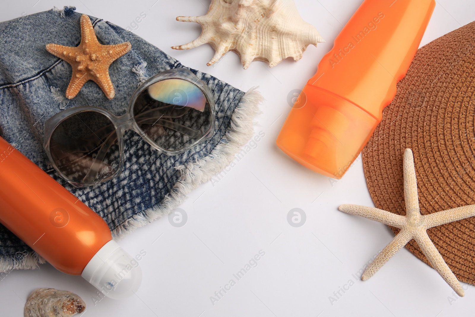 Photo of Flat lay composition with bottles of sunscreen on white background. Space for text