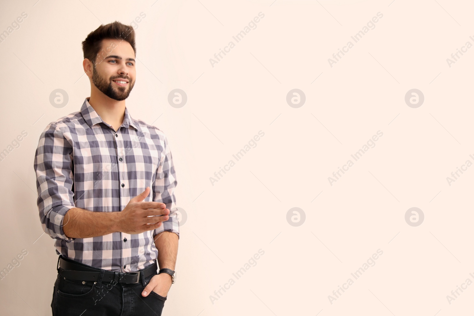 Photo of Man offering handshake on beige background, space for text
