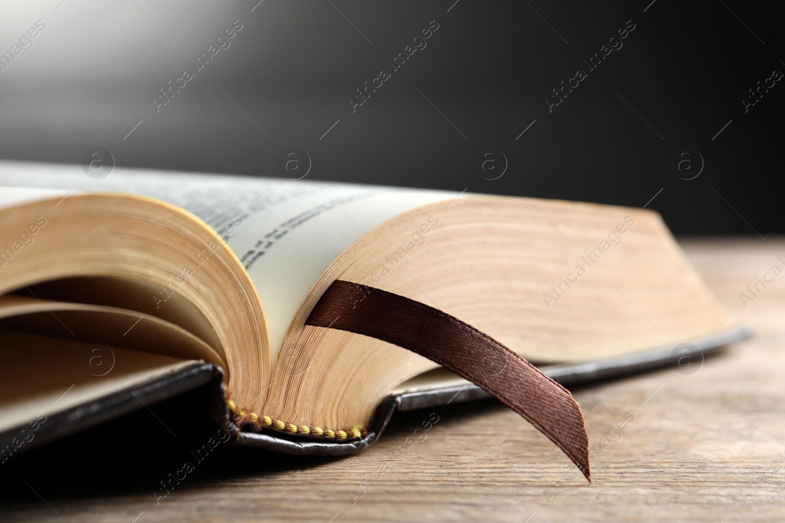 Photo of Open Bible on wooden table, closeup. Christian religious book