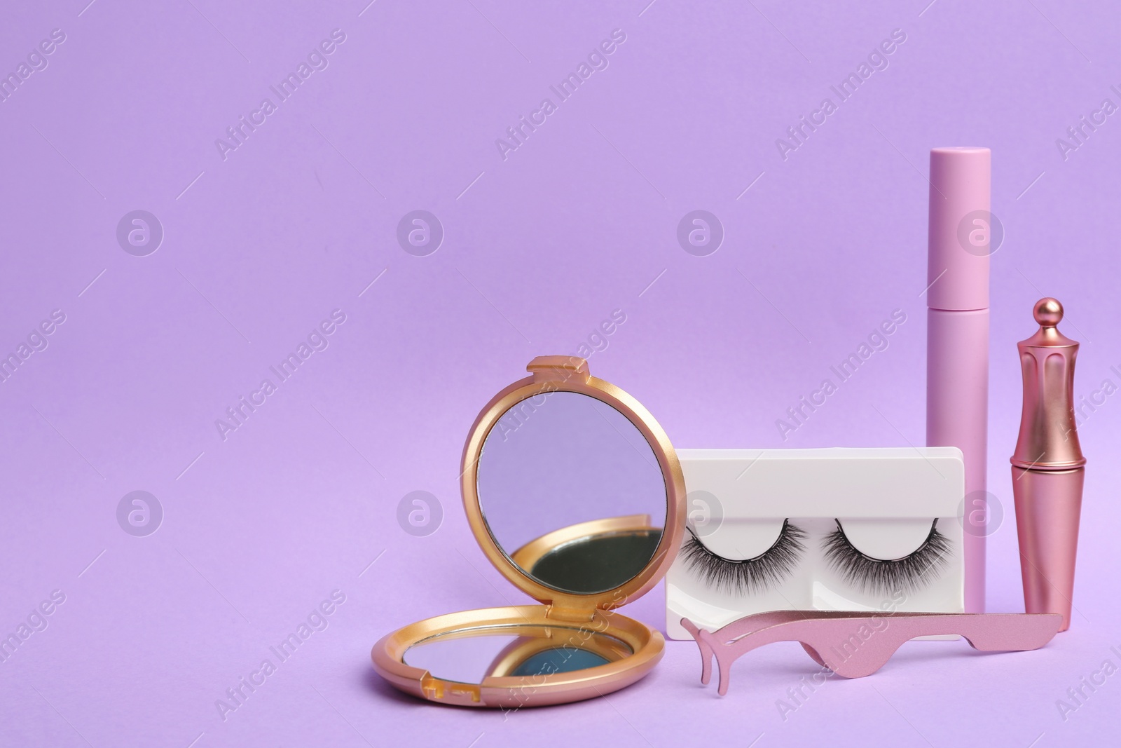 Photo of Magnetic eyelashes and accessories on violet background. Space for text