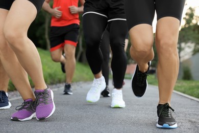 Group of people running outdoors, closeup view