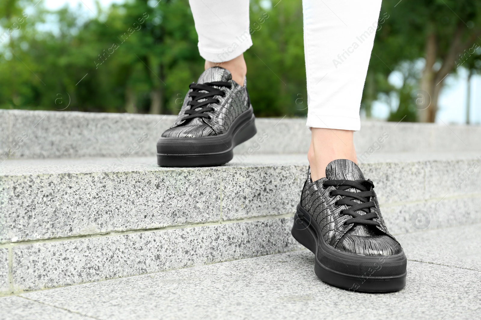 Photo of Woman wearing comfortable stylish shoes outdoors, closeup