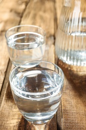 Photo of Glass of water on wooden table. Refreshing drink