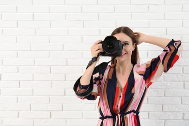 Photo of Professional photographer taking picture near white brick wall