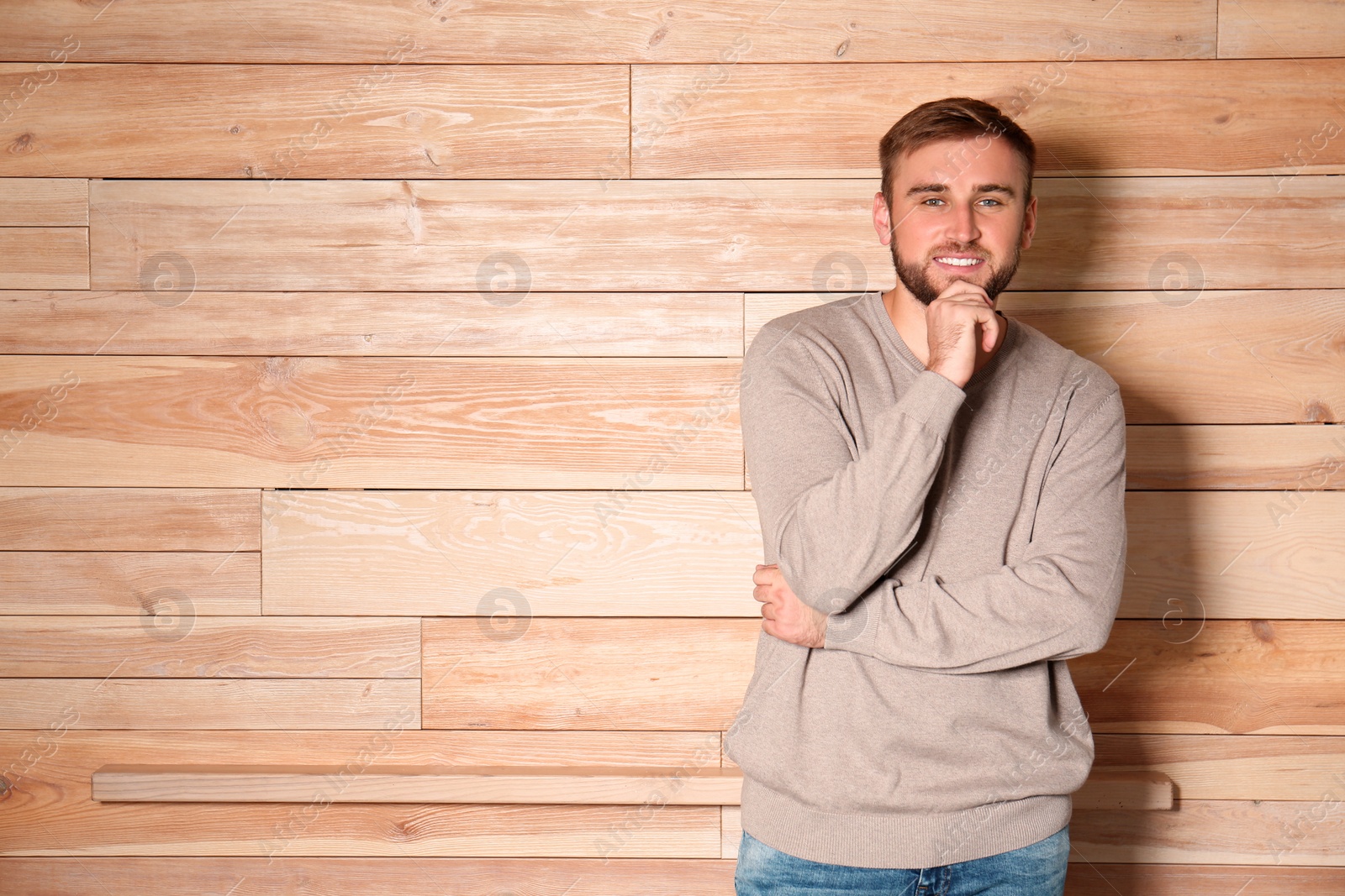 Image of Handsome man wearing warm sweater on wooden background. Space for text