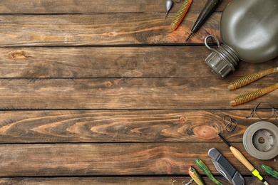 Photo of Flat lay composition with fishing equipment and space for text on wooden background