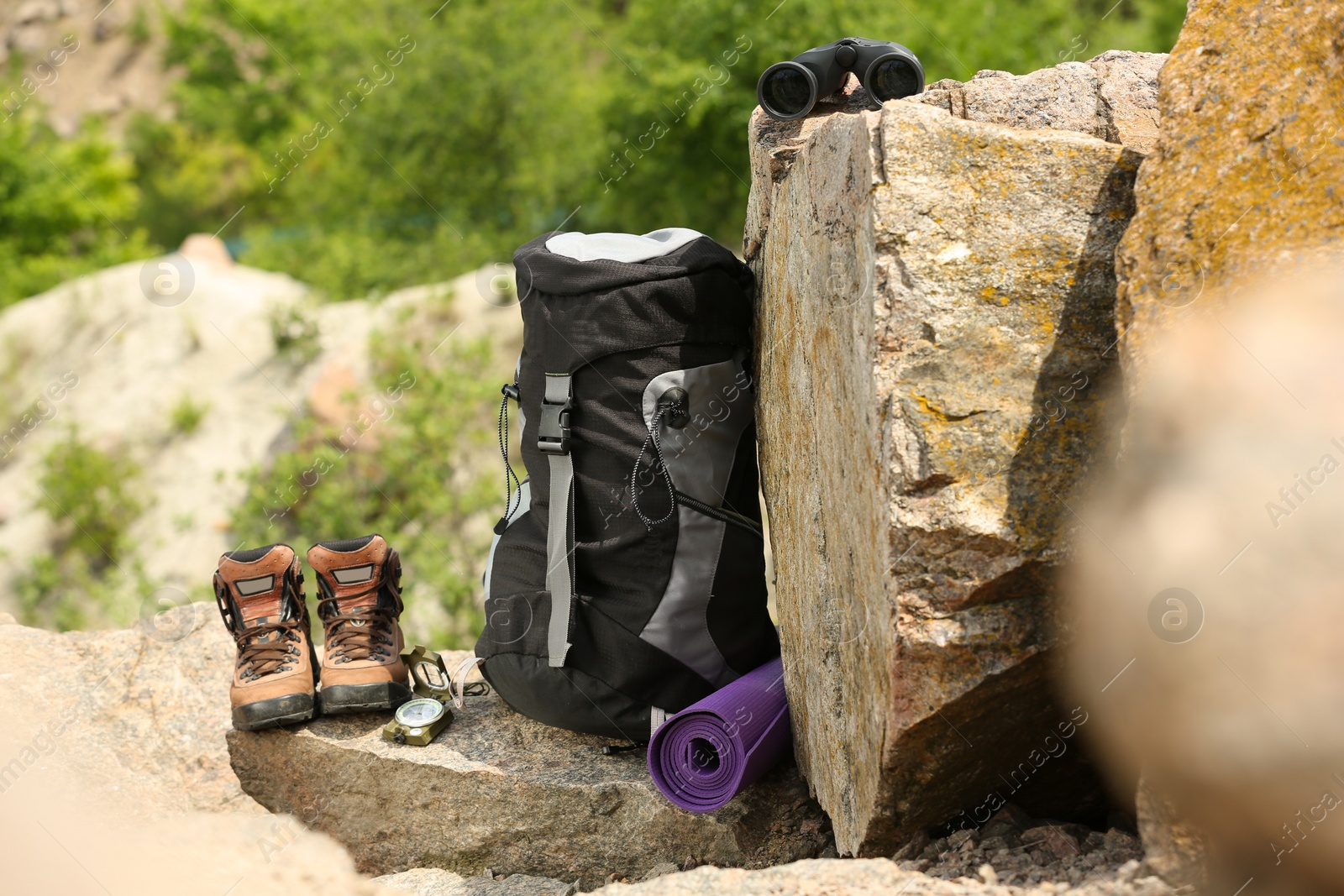 Photo of Backpack and camping equipment on rocks in wilderness