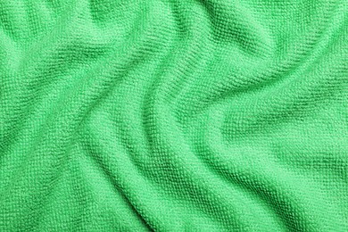 Photo of Crumpled light green microfiber cloth as background, closeup