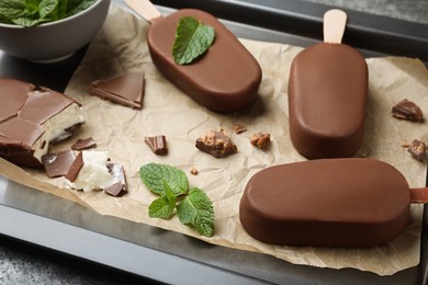 Photo of Glazed ice cream bars, fresh mint and chocolate on baking tray
