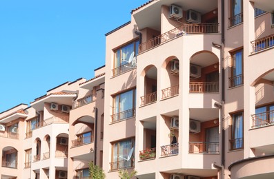 Photo of Exterior of beautiful residential building with balconies against blue sky