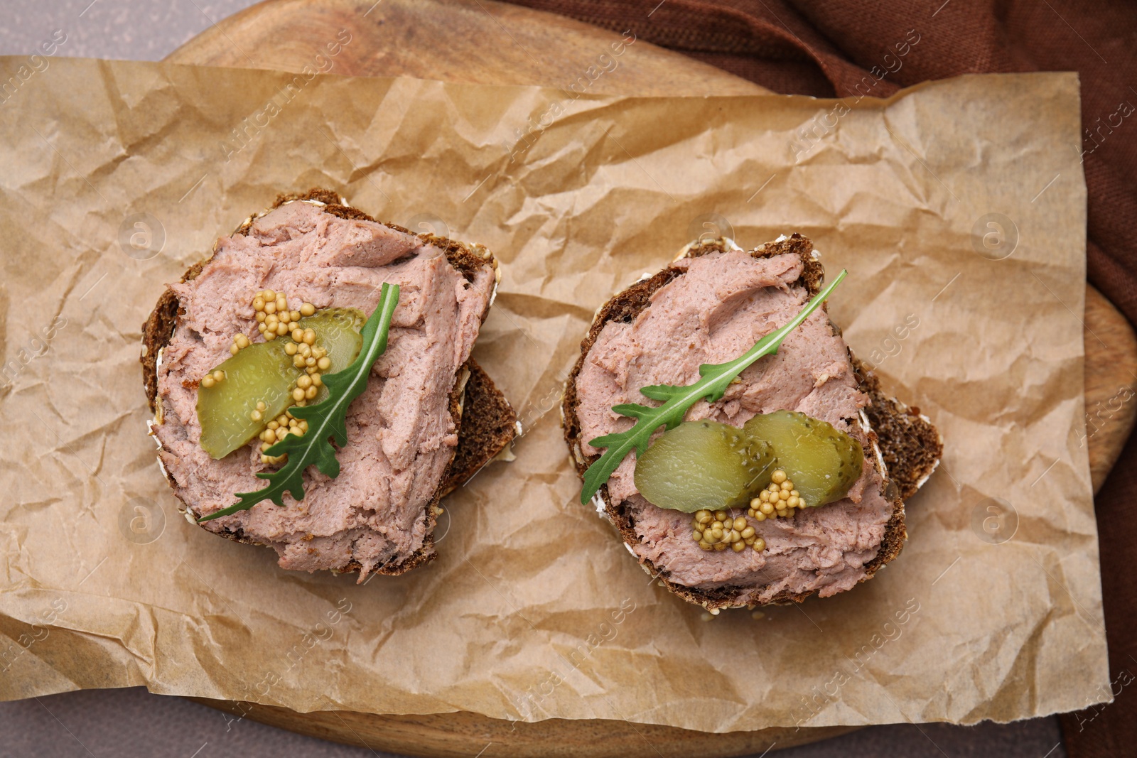 Photo of Delicious liverwurst sandwiches with pickled cucumber and mustard on grey table, top view