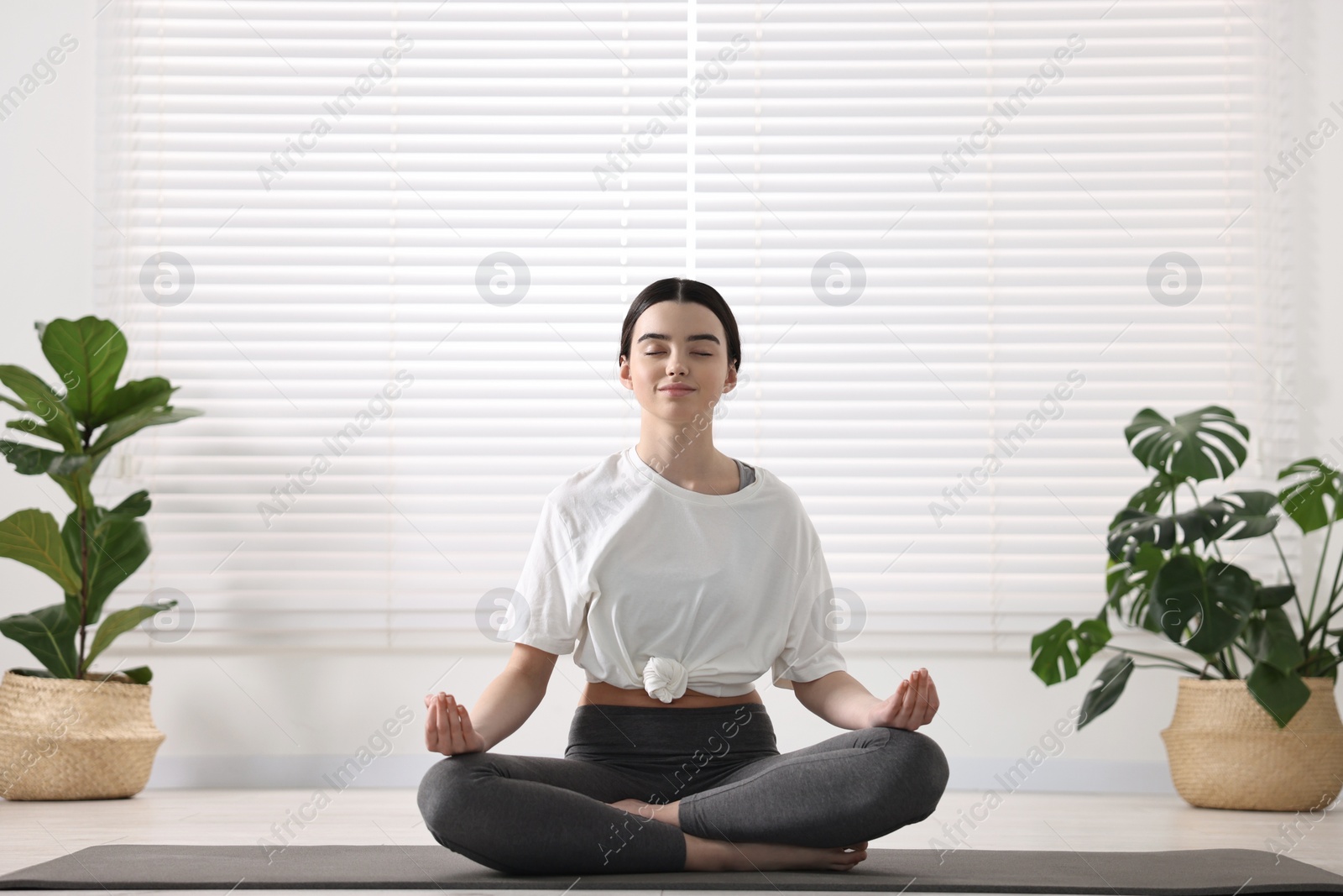 Photo of Beautiful girl meditating on mat in yoga studio