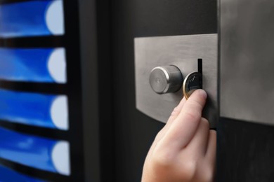 Using coffee vending machine. Girl inserting coin into acceptor, closeup with space for text