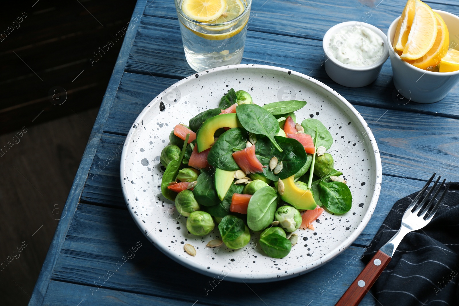 Photo of Tasty salad with Brussels sprouts served on blue wooden table