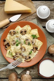 Photo of Delicious ravioli with ingredients on wooden table, flat lay