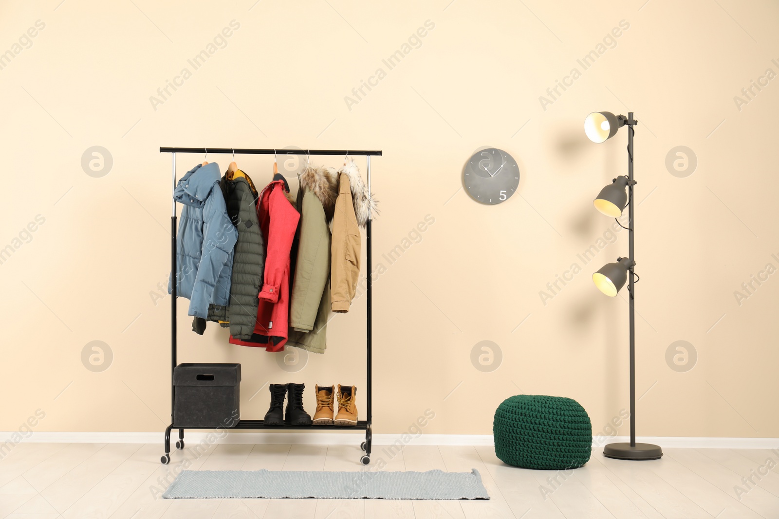 Photo of Stylish hallway interior with clothes on hanger stand