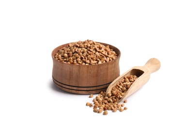 Bowl and scoop with uncooked buckwheat on white background